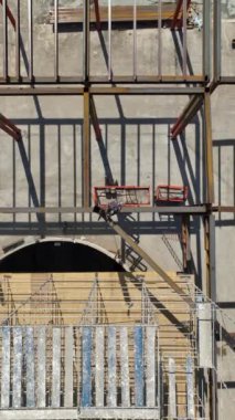 Büyük bir alışveriş merkezi şekillenirken 4K 'daki şehir perakendecisinin evrimine tanık olun. Metal yapıların kurulumunun dikey bir videosu.