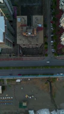 Deniz kenarındaki evler yükselirken 4K 'daki mimari mucizelere tanık olun. Sahil zarafetini yakalayan dikey bir video.