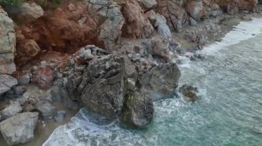 Turkuaz suları ve kayalık kıyıları olan gizli bir mücevherin üzerinde süzül, 4K 'da doğal güzellikler sergileniyor..