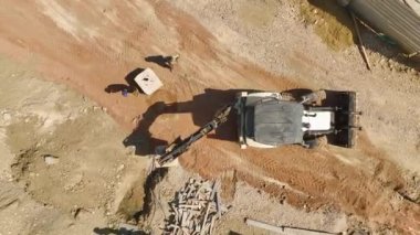 Elektrik hattı kurulumu için önemli materyaller taşıyan çalışkan bir traktörün havadan görüntüsünü yakalayın.