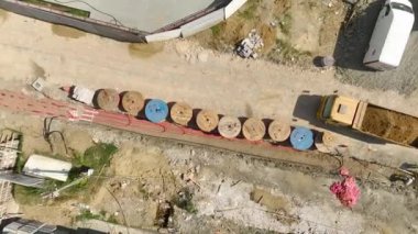 Elektrik nakil hatlarının kurulumu için ağır yük taşıyan bir traktörün görüntüsünü yükseltin..