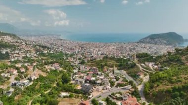 İnsansız hava aracı yaz aylarında gökyüzünde süzülürken şehir manzarasının dinginliğini keşfedin..