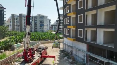 Akdeniz kıyısı boyunca evler şekillenirken kargo zeminlere yükleniyor.