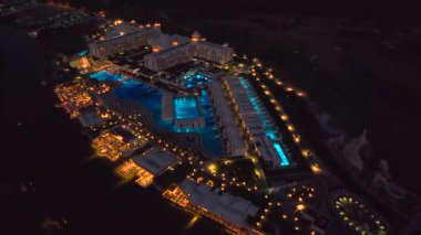 Türkiye 'nin Belek kentindeki elit bir tatil beldesinin nefes kesici gece manzarasını izleyin, büyüleyici 4K hava görüntüsü.