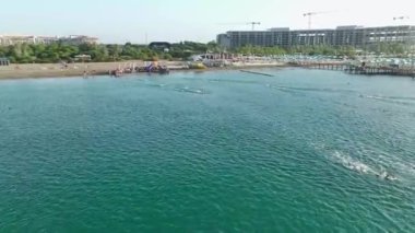 Bir triatlona 4K hava görüşü: yarışmacılar yüzer, bisiklet sürer ve manzaralı Akdeniz boyunca koşarlar.