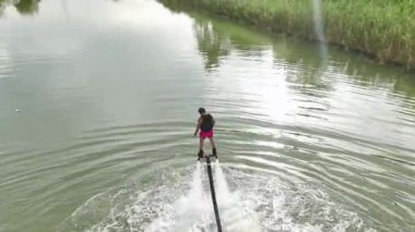 Yaz denizinin heyecanını hissedin. Bir kız, yatlar arasında uçan kaykayla heyecan yaratıyor. Canlı 4K ile gösteriliyor..