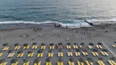 Günün muhteşem bir renkle bitmesini seyret. Sahildeki şezlongların konforundan, 4K ile çekilen..