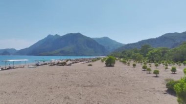 Antalya 'daki geniş kumlu sahile bakın, yumuşak kum ve mavi Akdeniz suları.