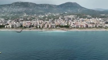 Bir Akdeniz sahilinin kumlarını süsleyen renkli bir plaj şemsiyesi mozaiğine hayranlık duyun, yukarıdan canlı 4K olarak izleniyor..