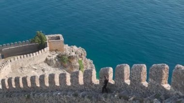 Güneş ışığının Alanyas kıyı kalesinin antik taşlarında dans edişine bakın, kalıcı güzelliği 4K berraklığıyla vurgulanmış..