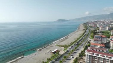 Kıyı şeridi siluetine hayran kaldım. Tek renkli bir adam. Siyah kıyafeti sahile karşı 4K 'da çekilmiş..