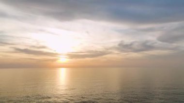 Bulutlu bir deniz manzarasının dingin güzelliğini keşfedin alacakaranlıkta, güneşin son ışıklarının ufuk çizgisine ulaştığı yerde, 4K 'da yakalanan.