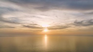 Bulutlu bir okyanusta güneşlerin veda edişini, bastırılmış ışığının baş döndürücü 4K büyüsünü yaşayın..