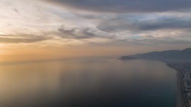Gün batımının deniz üzerindeki bulutlarla dans ettiği bulutlu gökyüzünün zarafetine hayret etmek, 4K 'da sergilendi..