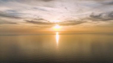 Gün batımını öpen bulutları izle, sakin renkler denizini boya, her dalga ve fısıltı 4K 'da yukarıdan yakalanır..