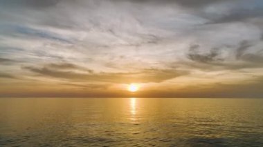 Gün batımını öpen bulutları izle, sakin renkler denizini boya, her dalga ve fısıltı 4K 'da yukarıdan yakalanır..
