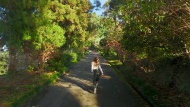 Adımlardaki dinginliği tecrübe edin, güzel bir model Batumi 'nin botanik harikalarında gezinirken, büyüleyici 4K' da çekiliyor..