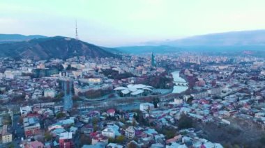 Şehir manzarasının görkemli renklerde parladığı Tiflis üzerindeki altın saate hayret ediyorum. Her anı havadan 4K olarak kaydediliyor..