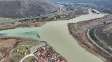 Mtskheta 'da güneşin doğuşunu selamlayın. Katedral gölgeler nehir boyunca uzanıyor. 4K' da güzel bir sabah manzarası var..
