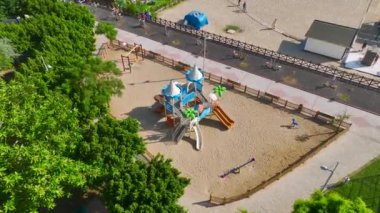 Bir çocuk cennetinin üzerinden uç, oyun sevinciyle vızıldayan parlak bir oyun alanı, canlı 4K detaylarıyla yakalanmış..