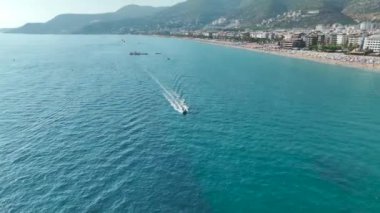 Yat, plaj ve mavi gökyüzünün uyum içinde olduğu bir yaz senfonisi deneyin, her detayı 4K 'da çıtır çıtır.