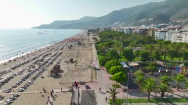 Tembel plaj günlerinin canlandığını gör. Gökyüzünden 4K 'da yakalanan güzel gök mavisi deniz tarafından yaz güneşini emerek..