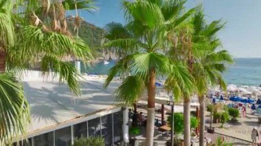 Yaz güneşinin altında kumlu sahillerin üzerinden uç. Gök mavisi denizin ışıldadığı, parlak, berrak 4K ile yakalandığı yerde..