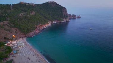 Sahilin alacakaranlıkta canlandığını, dalgaların solan ışığın altında sırlarını fısıldadığını, güzel bir şekilde 4K 'da çekildiğini gör..