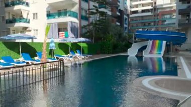 Işıl ışıl havuzu olan rahat bir kompleksin üzerinden uçmak, suyun güneşin altında parladığı, kristal berraklığında 4K 'da yakalandığı yer..