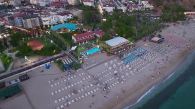 Akşamın sakinliğine tanık olun. Kumlu kıyılar alacakaranlığı kucaklıyor. Gün huzurlu bir şekilde sona eriyor..