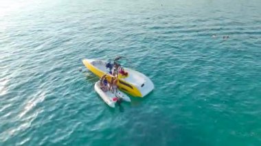 Sahilin yakınındaki jet ski ve teknelerle dolu neşeli sahillere tanık olun. Suyun eğlenceli bir şekilde buluştuğu, 4K 'da dinamik bir şekilde yakalandığı sahile..
