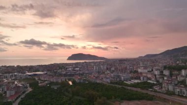 Güzel pembe çizgili günbatımı gökyüzünün altında bir Türk şehrinin panoramik drone görüntüleri.