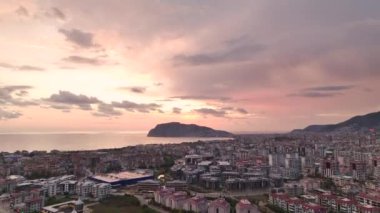 Gökyüzüne hakim pembe bulutların hakim olduğu bir Türk şehrinin üzerine çekilmiş günbatımı renkleri senfonisi..