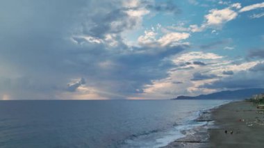 Huzurlu mavi tonların Akdeniz 'in üzerindeki bulutlu günbatımı gökyüzüne karışmasını izle..