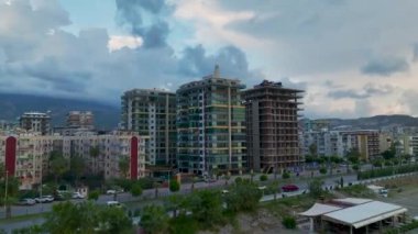 Deniz kıyısındaki yoğun bir inşaat sahasının yukarıdan görünüşü, yakınlarda dalgalar çarpıyor..