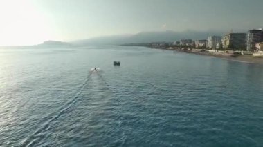 Huzurlu bir yaz günü, bireyler kıyı boyunca SUP ile uçarken, gökyüzünden görülüyor..