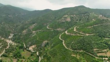 İnsansız hava aracı, orman dağlarının parlak yeşil arasında bir köyün tuhaf cazibesini yakalar..