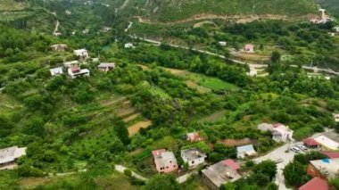 Yukarıdan, bir dağ köyü senfonisi ve yeşil orman uyumlu hava görüntüleriyle yakalandı..