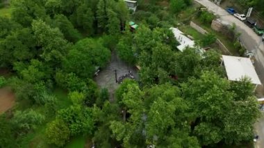 Yoğun, canlı yeşil ormanlarla çevrili zamansız bir dağ köyünün üzerinden uç..