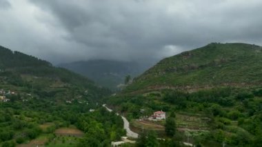 Yukarıdan tenha bir dağ köyüne bakın, nefes kesen yeşil orman inzivasına yerleşmiş..