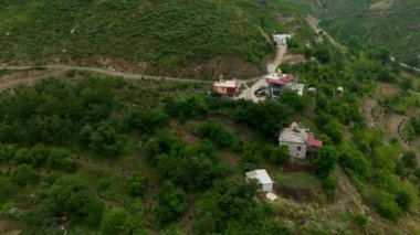 Geleneksel dağ köyü yaşamı, etrafını çevreleyen ormanın derin renkleriyle kaplıdır..