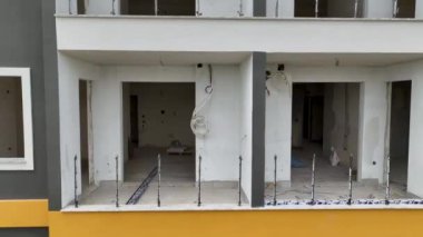 Deniz kenarındaki büyük bir inşaat alanının çok katlı bir cephesi var..