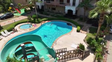 Havuz kenarındaki gökyüzü manzaralı modern yerleşim biriminde şık yaşam tanımlanır..