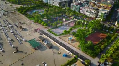 İnsanlar güneşlenirken yaz saadetine dal ve kristal berraklığında deniz maceralarının tadını çıkar..