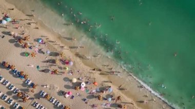 Deniz kıyısında huzur hüküm sürerken, güneş pansiyonları kıyı şeridinde, büyüleyici 4K 'daki yaz dalgalarının dinlendirici sesleri eşliğinde.