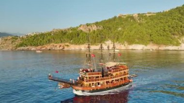 Çarpıcı Akdeniz adalarıyla çevrili ahşap bir gemide şiddetli korsan savaş canlandırmalarına tanık olun..