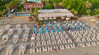 Akdeniz kıyısındaki canlı bir sahil kulübünün üzerinden uç. Güneş, kum ve eğlencenin bir araya gelip canlı 4K 'da yakalandığı yer..