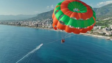 Günbatımında gökyüzüne yelken açmak, yüksek kaliteli 4K ile yakalanan bir Akdeniz parasailing gezisi sırasında..