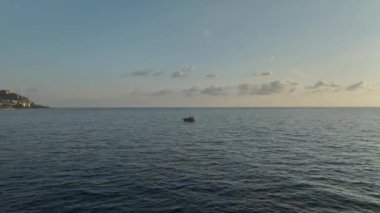 Deniz günbatımının güzelliğini yansıtır..