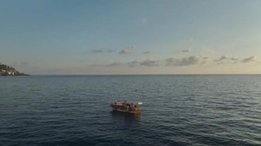 Balıkçılar kıyı kenarında gün batımını severler..